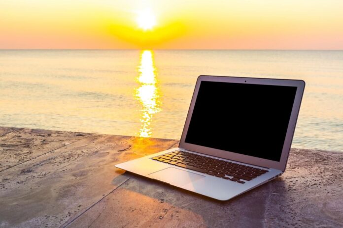 laptop-stone-surface-sea-background