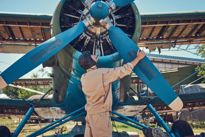pilot-mechanic-full-flight-gear-checks-propeller-his-retro-military-aircraft-before-flight