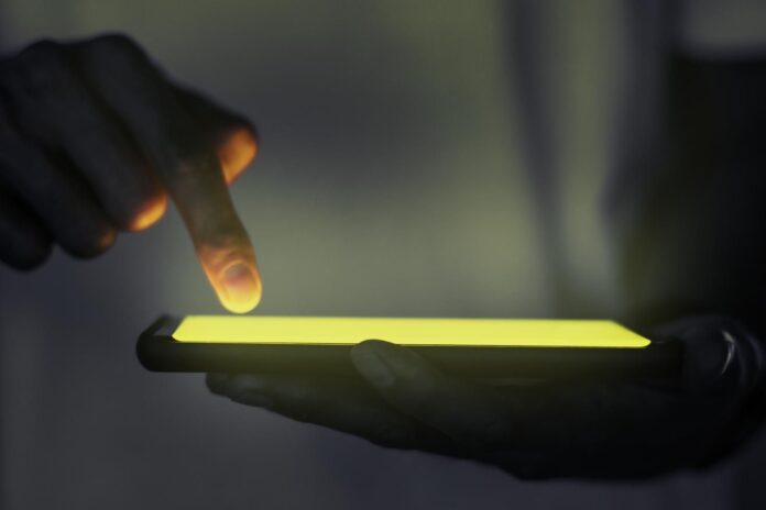 hand-touching-illuminated-smartphone-screen