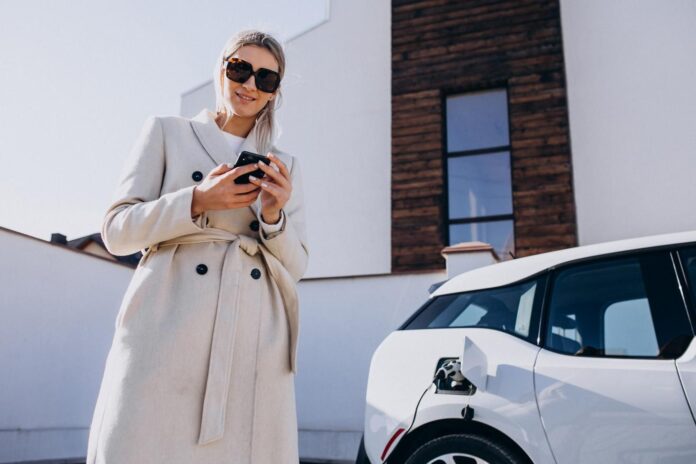 woman-charging-electro-car-using-phone